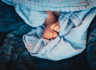 Closeup newborn baby boy feet on blue blanket