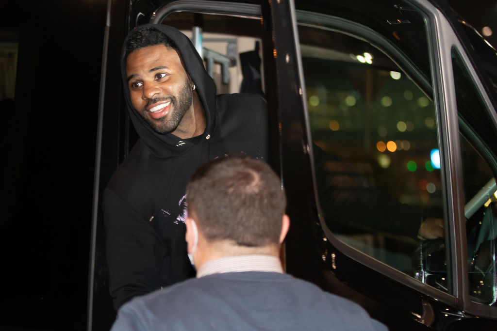 Jason Derulo is seen in a car smiling at the people after...