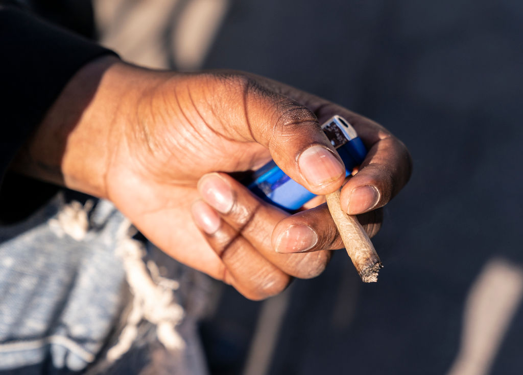A New Yorker holding a cannabis joint after New York becomes...