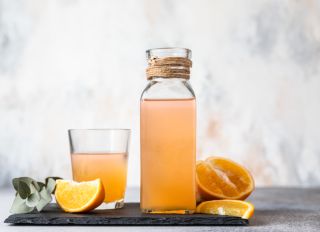 Orange Lemonade In Glass And Bottle With Fresh Orange. Refreshing Summer Drink.