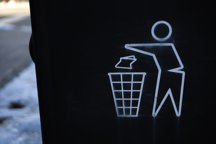graphic of person disposing trash in waste receptacle on public sidewalk