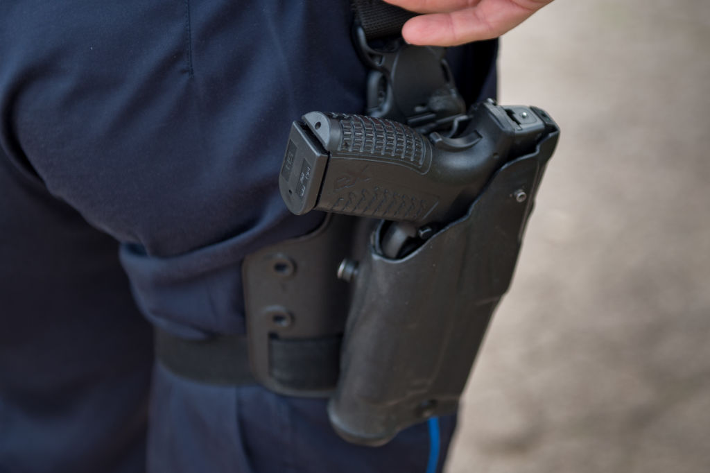 A policeman's gun seen in close-up attached to the belt...