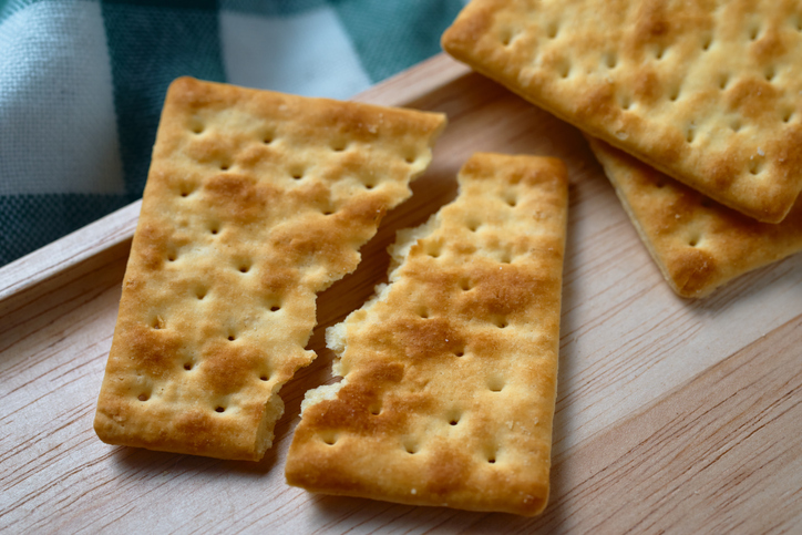 Craked wholegrain cracker on the wooden tray
