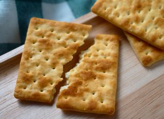 Craked wholegrain cracker on the wooden tray
