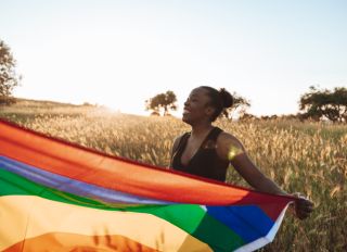 LGBTQ+ pride, woman holding a rainbow flag