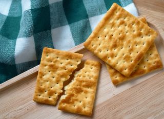 Cracked wholegrain cracker on the wooden tray
