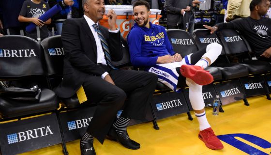 Dell Curry chats with his son Golden State Warriors' Stephen Curry (30) while sitting on the sideline before the start of their NBA game against the Charlotte Hornets at the Oracle Arena in Oakland, Calif. on Friday, Dec. 29, 2017. (Jose Carlos Fajardo/Ba