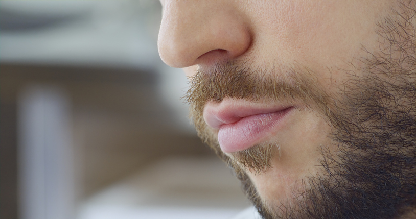 Genç adamın sakallı ve pembe dudakları