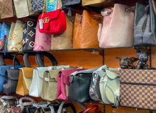Rows of Counterfeit Fake Poor quality Handbags such as Chanel & Louis Vuitton being sold at backstreet markets to unknowing tourists. Good copies that fool the buyer but often fall apart very quickly due to cheap and inexpensive quality