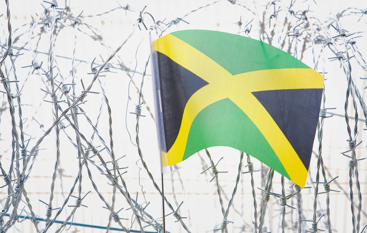 The flag of Jamaica on barbed wire.