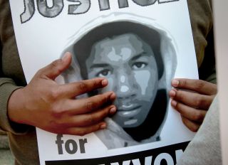 A poster of Trayvon Martin is displayed during a rally demanding justice for Martin in front of the Ronald Dellums Federal Building in downtown Oakland, Calif on Saturday July 20, 2013. The crowd joins a nationwide day of protests against last week's acqu