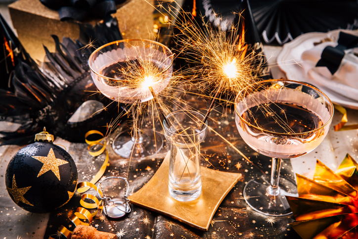 Happy New Year - two glasses of champagne with sparkler on decorated festive table