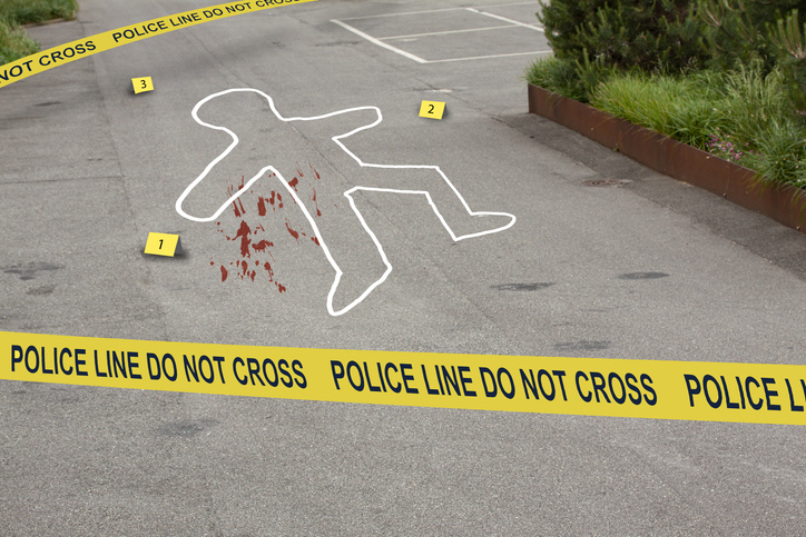 Crime scene, do not cross police tape. Chalk outline circles a human body from a murder or traffic accident, with numbered marks near the evidence