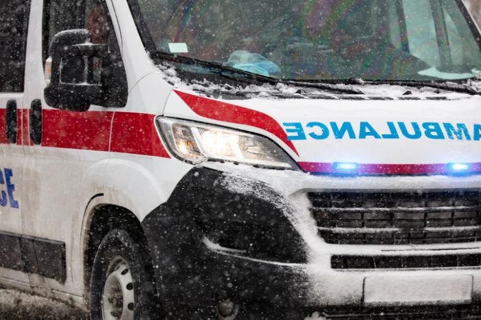 Yoğun kış kar yağışı koşullarında trafikte acele eden 911 ambulans minibüsü.