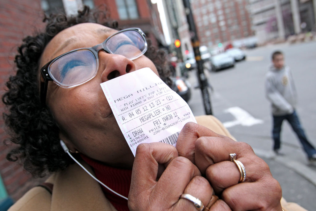 (Boston, MA) Carlyene Prince-Erickson of Stoneham holds up her Megamillions ticket she just bought using her grandmothers old number from twenty years ago at a 7-Eleven Thursday, March 29, 2012. Staff Photo by Matt Stone