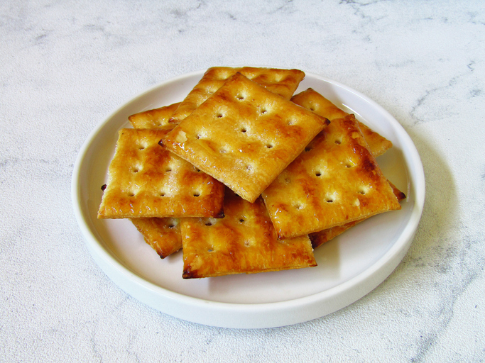 Crackers on a white ceramic plate on a white background