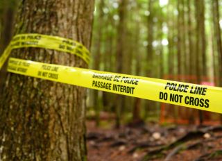 Police line in the forest at a crime scene