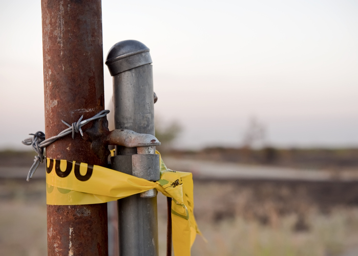 Cartel - Caution Tape at Sunrise on an Entrance to Burned Field