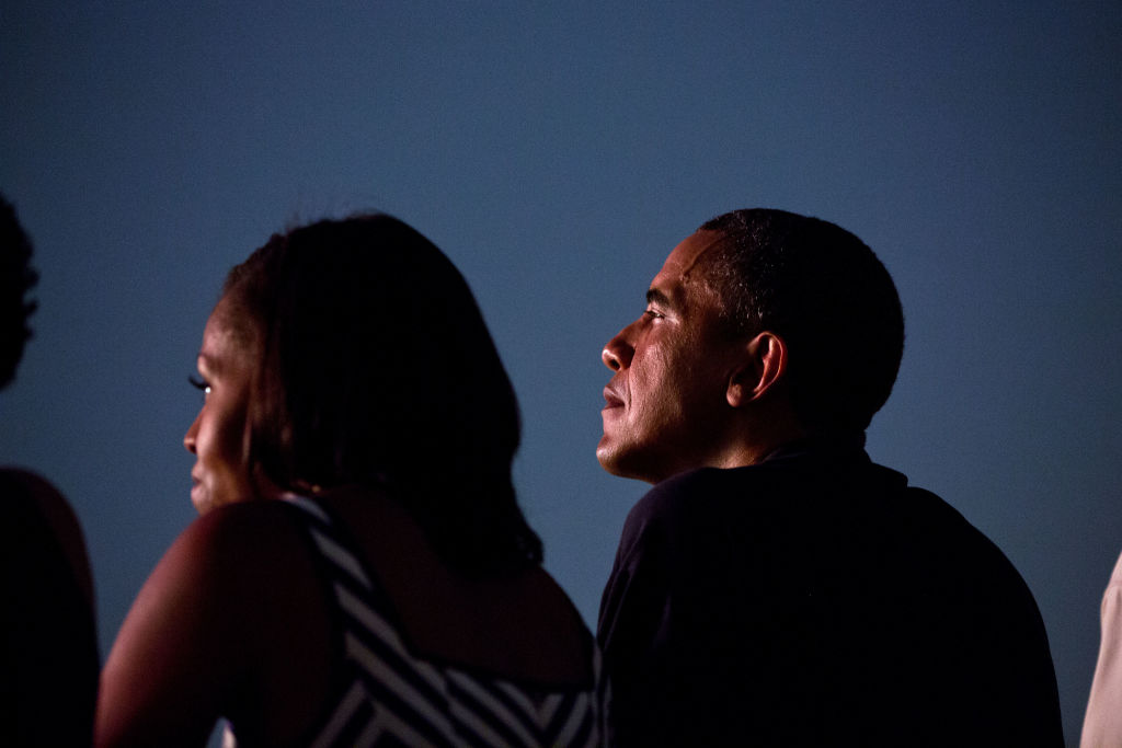 President Barack Obama and First Lady Michelle Obama watch from the White House roof as fireworks erupt over the National Mall, July 4, 2012
