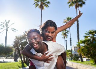Cheerful portrait of a young African American couple on their holidays on an island.