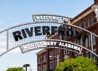 Welcome to Riverfront park illuminated sign with buildings in background in capital Alabama city of Montgomery in old town