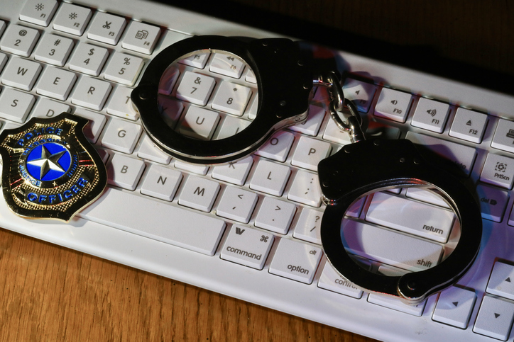 Revenge Porn Lawsuit - Concept of cybercrime and cybersecurity with keyboard, handcuffs, and police badge
