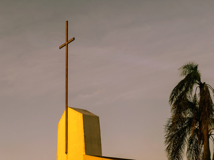 Church exterior with cross sign over sky