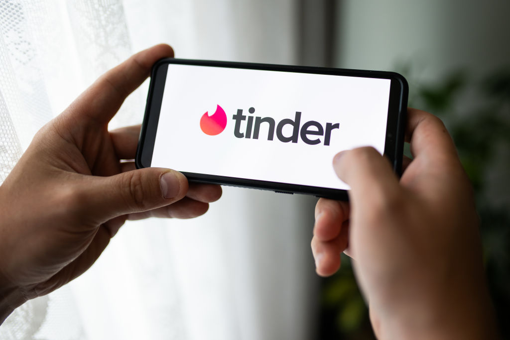 In this photo illustration a Tinder logo seen displayed on a...