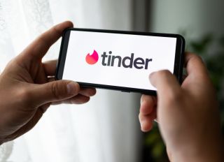 In this photo illustration a Tinder logo seen displayed on a...
