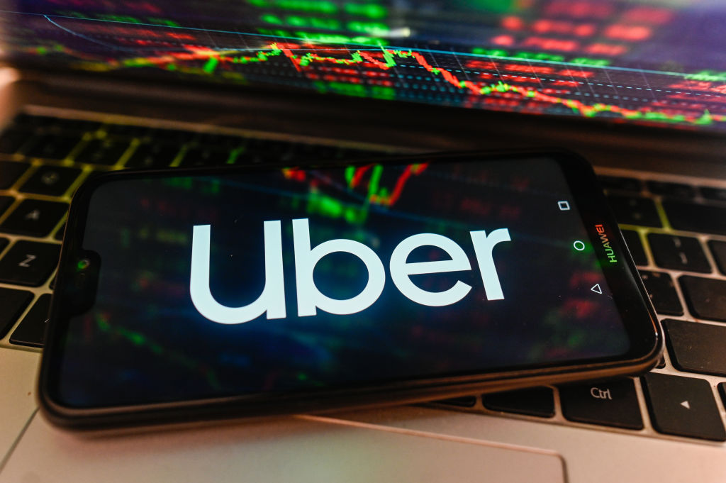 In this photo illustration, Uber logo is displayed on 