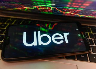 In this photo illustration, Uber logo is displayed on a...