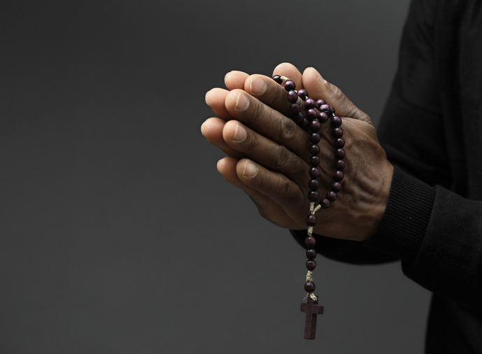 man praying to God with the hands together on black background with people stock image stock photo