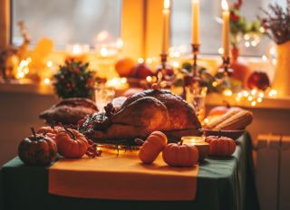 Thanksgiving holiday dinner table setting with fall decoration and pumpkins