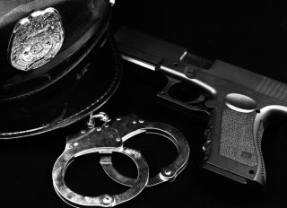 Police and justice concepts - officers hat, firearm, and handcuffs