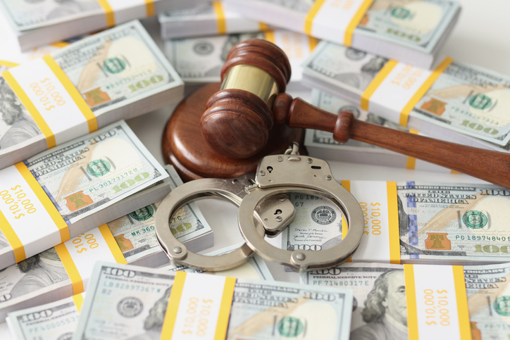 An handcuffs and judges on packs of dollars, close-up