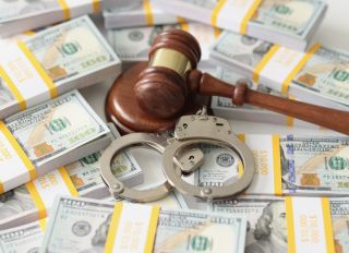 An handcuffs and judges on packs of dollars, close-up
