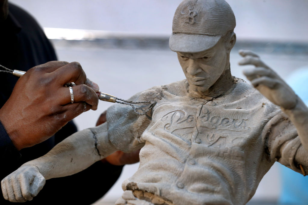 Branly Cadet repairs cracks in a maquette he used during the process of sculpting a Jackie Robinson statue at his studio in Oakland, Calif. on Wednesday, April 26, 2017. The Los Angeles Dodgers commissioned Cadet to sculpt a statue of Robinson stealing ho