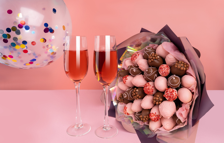 Valentines Mocktails on a pink background. Bouquet of Strawberries in pink chocolate.