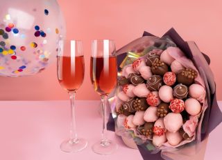 Valentines Mocktails on a pink background. Bouquet of Strawberries in pink chocolate.