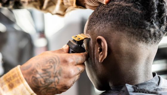 Barber cutting young boys hair in barbershop - closeup