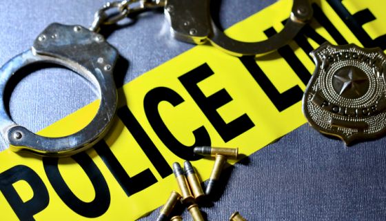 Crime and justice concepts - handcuffs, badge, bullets, and caution tape
