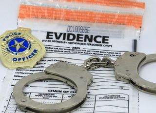 Handcuffs, police badge, and evidence container