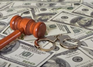 Judge gavel, handcuffs and money banknotes. Economic crime, scam, bail and corruption concept.