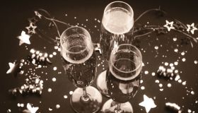 Celebratory champagne glasses among festive decorations in vintage sepia tone