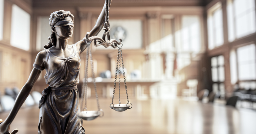 Legal law concept statue of Lady Justice with scales of justice in courtroom background