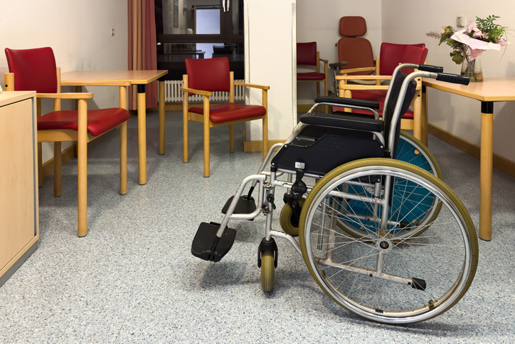 Quiet room with empty wheelchair and warm wooden furniture