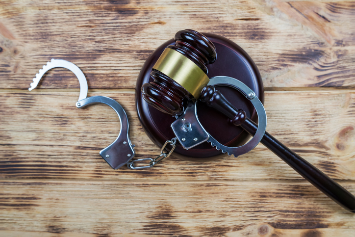judge gavel and handcuffs on wooden background