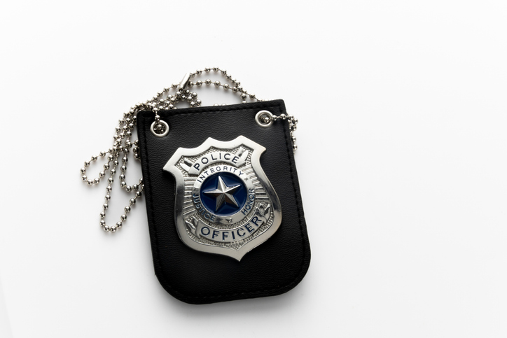 Police badge hanging on a key chain, reflecting light
