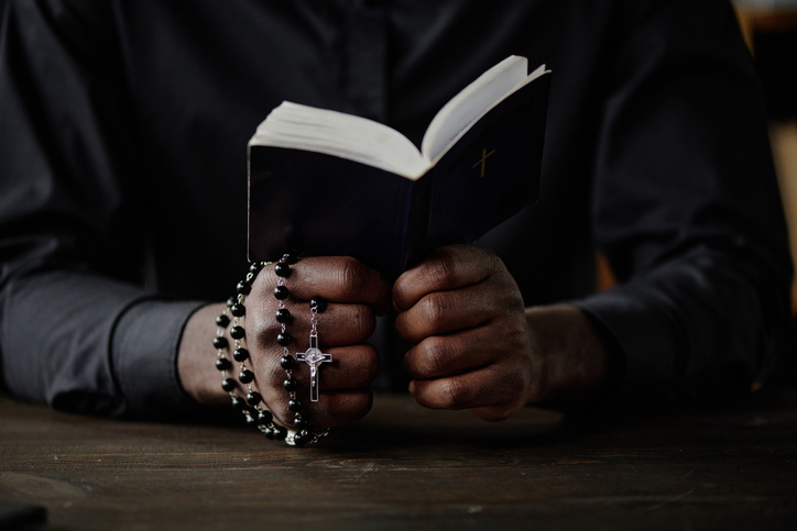 Male Hands Holding Bible and Rosary