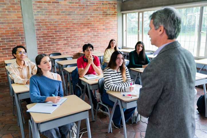 Group of students paying attention to their teacher at school